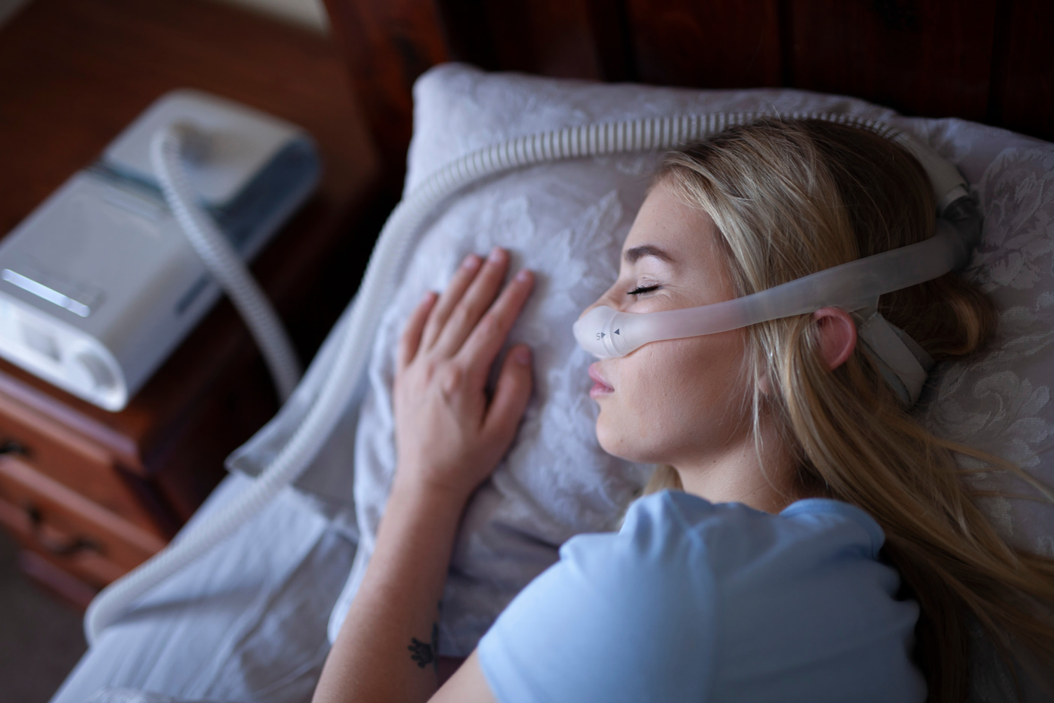 Mulher com apneia do sono dormindo com CPAP
